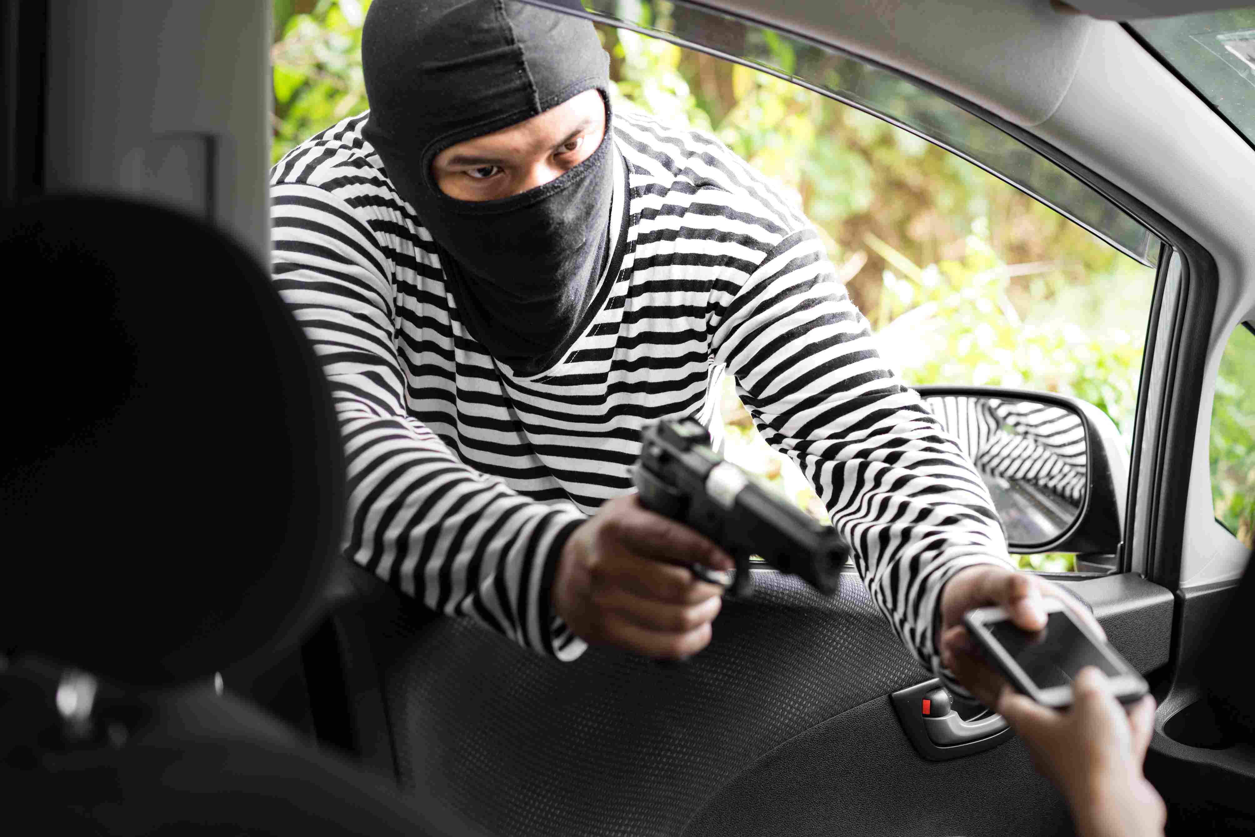 A driver being robbed at gun point